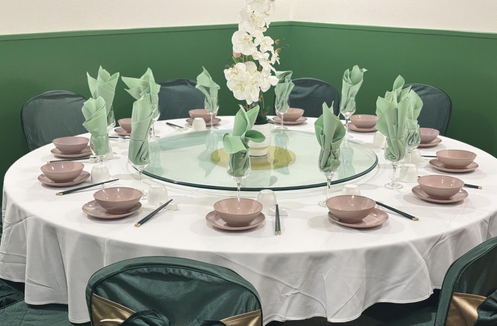 Elegant private dining table with white tablecloth, green napkins, and floral centerpiece at Bao Kee Restaurant, a Chinese Restaurant in Hacienda Heights
