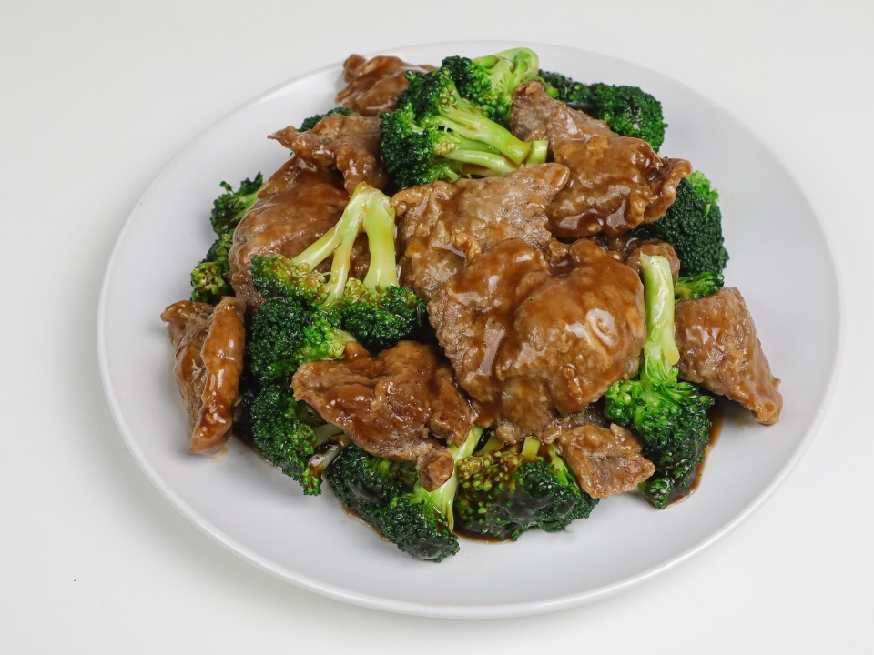 Beef and broccoli in brown sauce on a white plate