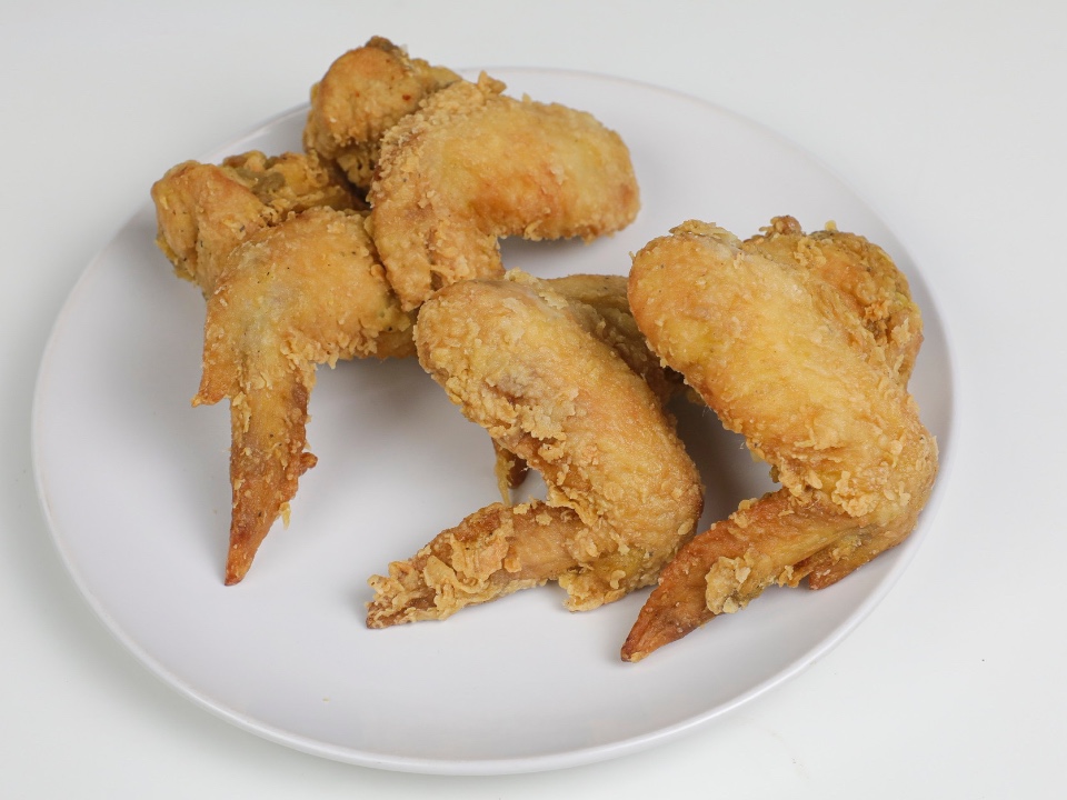Crispy fried chicken wings on a white plate