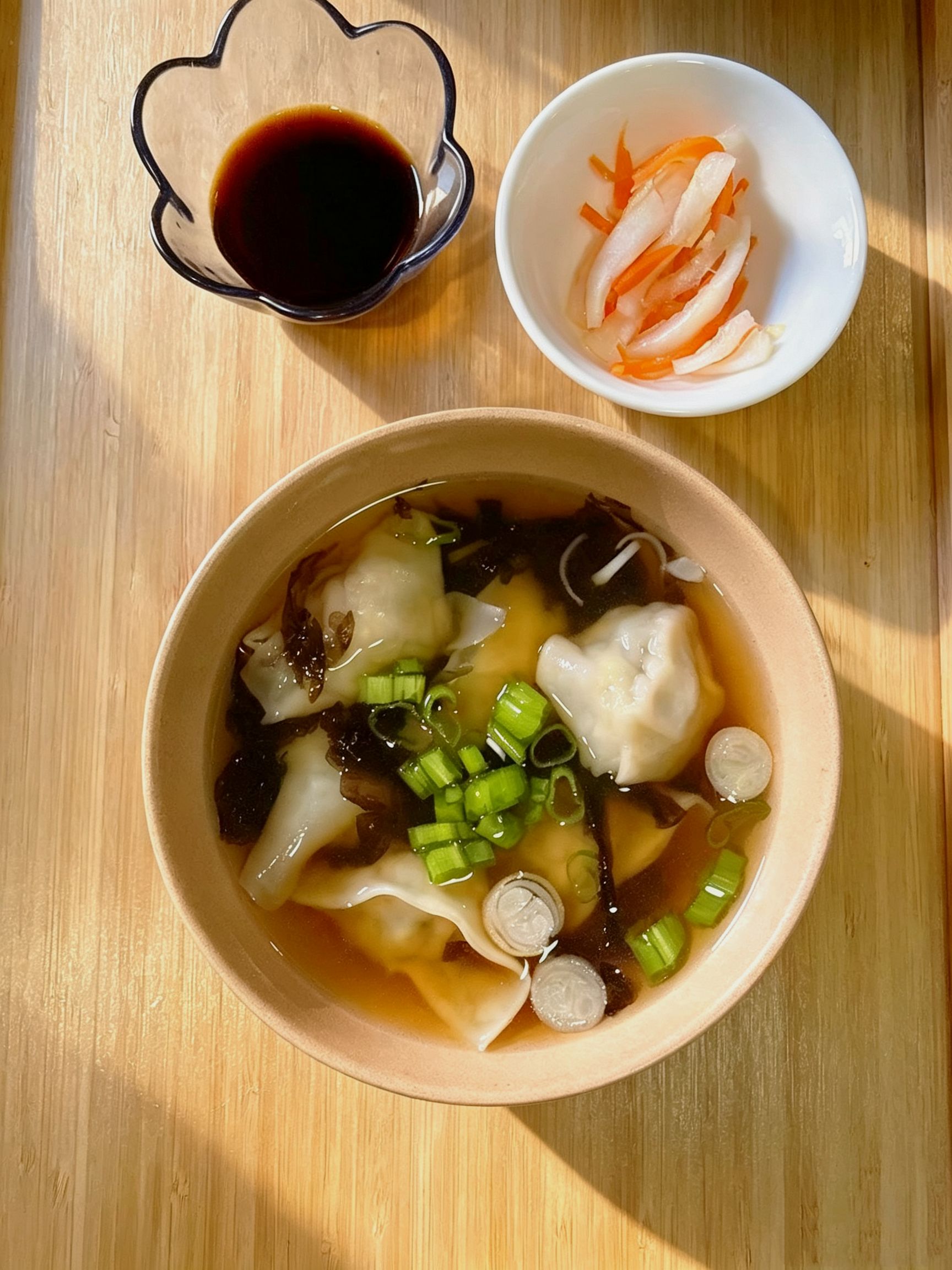 Wonton soup with green onions, seaweed and side soy sauce plus pickled veggies at Cafe On Seneca, an Asian Fusion Restaurant in Ridgewood