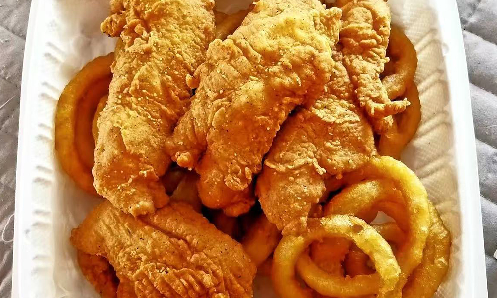 Crispy fried chicken strips served with golden onion rings at Cajun Bros, a Seafood Restaurant in Waxahachie