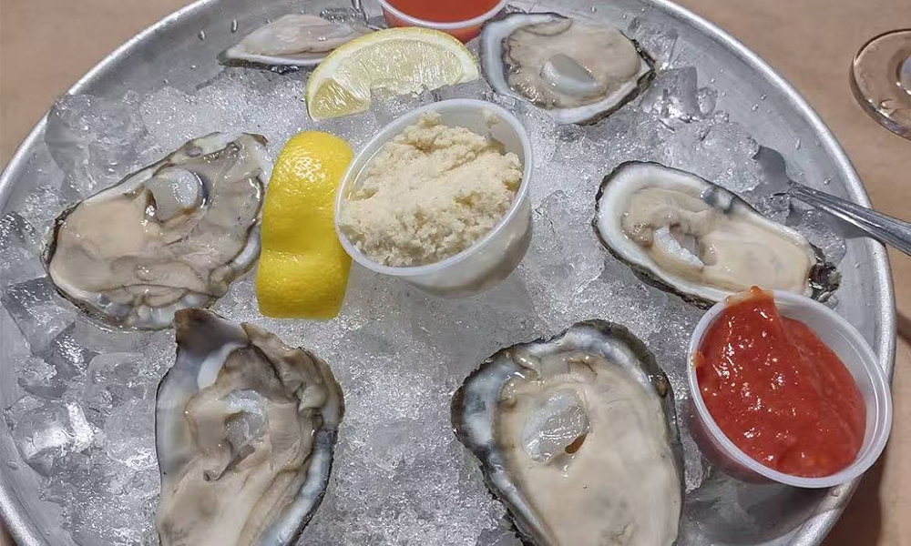 Fresh raw oysters on ice with lemon and sauces at Cajun Bros, a Seafood Restaurant in Waxahachie