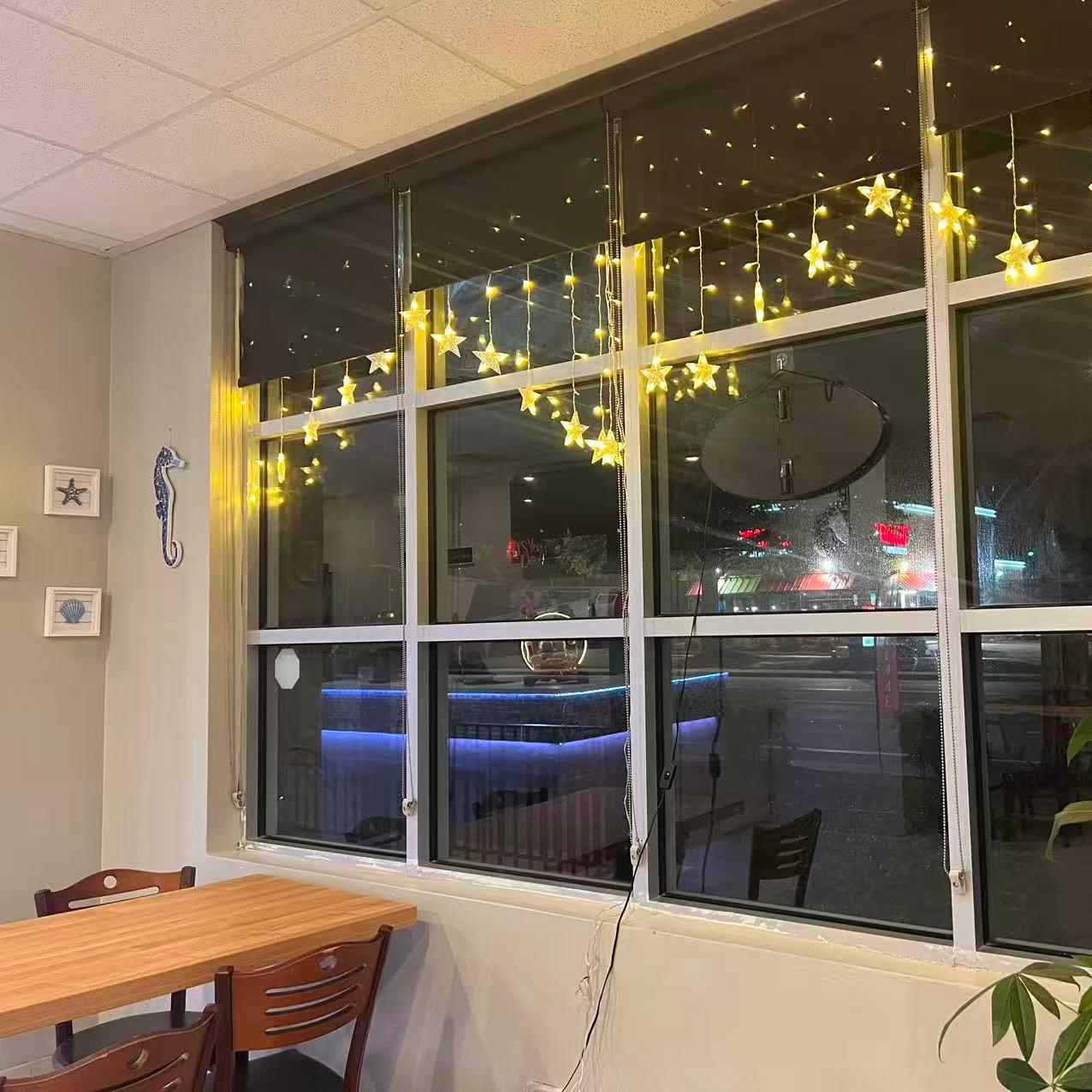 Window decorated with star lights and nautical items at Cajun Claws & Wing, a Seafood Restaurant in Hartsville