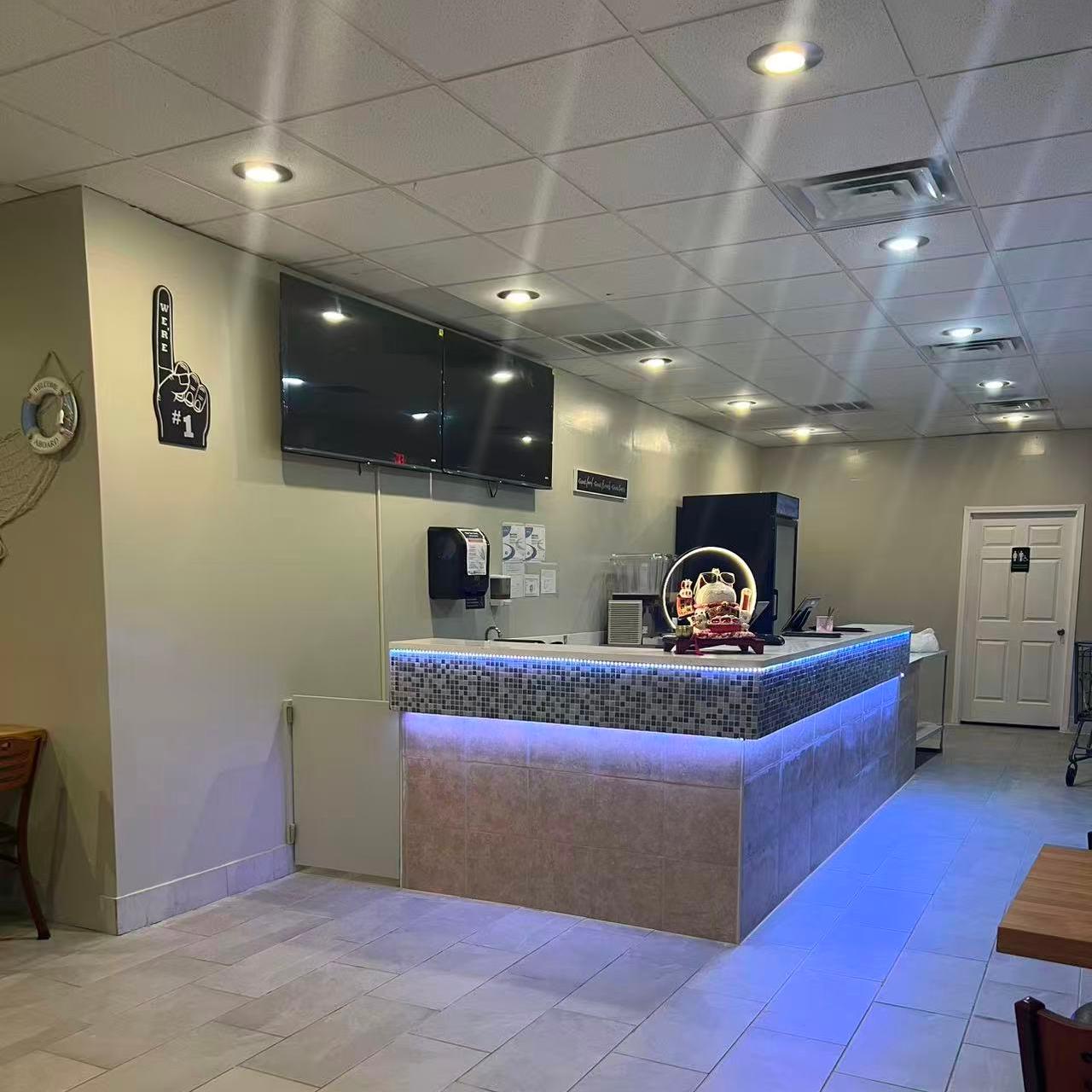 Interior counter with blue lighting and TV screens at Cajun Claws & Wing, a Seafood Restaurant in Hartsville