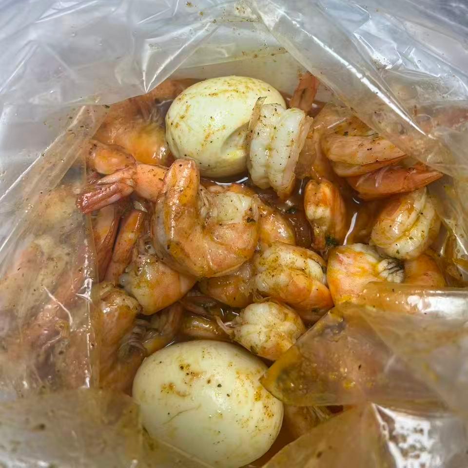 Assorted seafood with eggs in seasoned sauce at Cajun Claws & Wing, a Seafood Restaurant in Hartsville