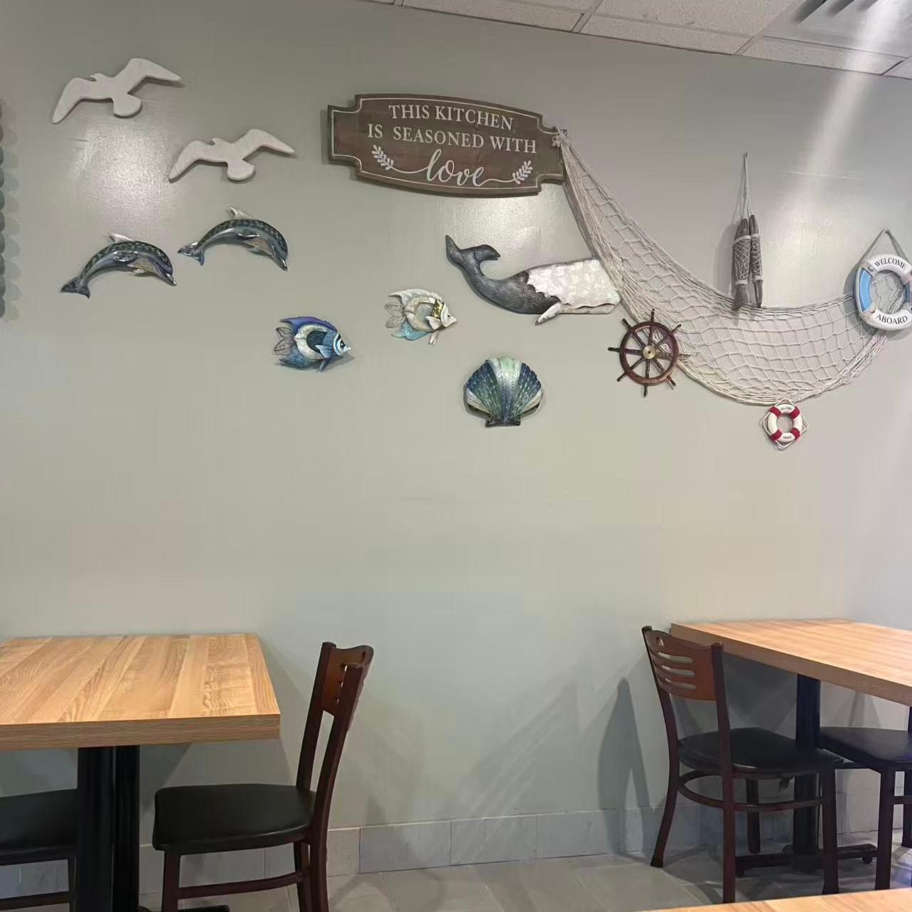 Nautical - themed wall decor with marine animals and a sign at Cajun Claws & Wing, a Seafood Restaurant in Hartsville
