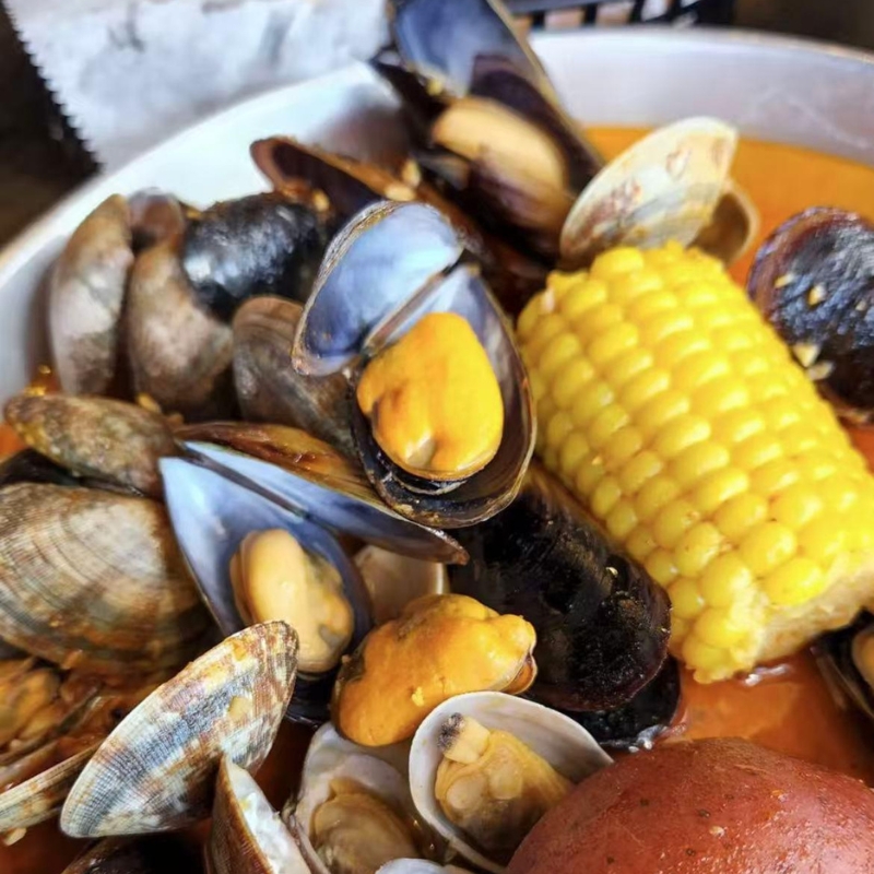 Cooked mussels, clams and corn in sauce at Cajun Express, a Seafood Restaurant in St Paul