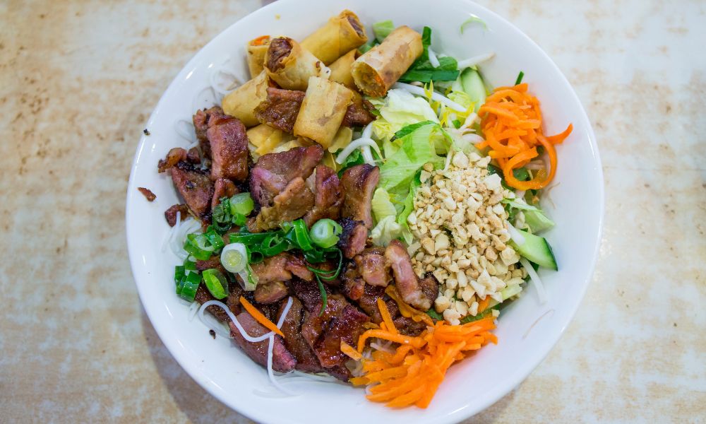 Grilled pork vermicelli bowl with spring rolls, veggies, and peanuts at Canto House, a Chinese restaurant in Philadelphia