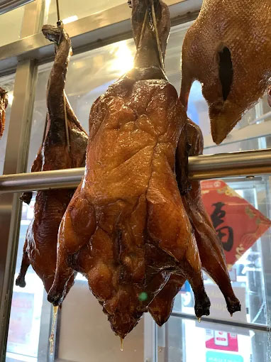 Roasted Peking ducks hanging in a display window at Canto House, a Chinese restaurant in Philadelphia