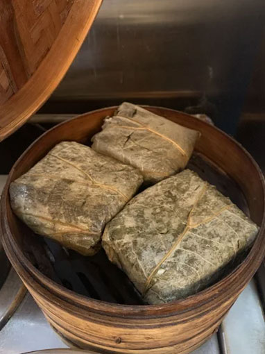 Steamed lotus leaf-wrapped sticky rice in a bamboo steamer at Canto House, a Chinese restaurant in Philadelphia