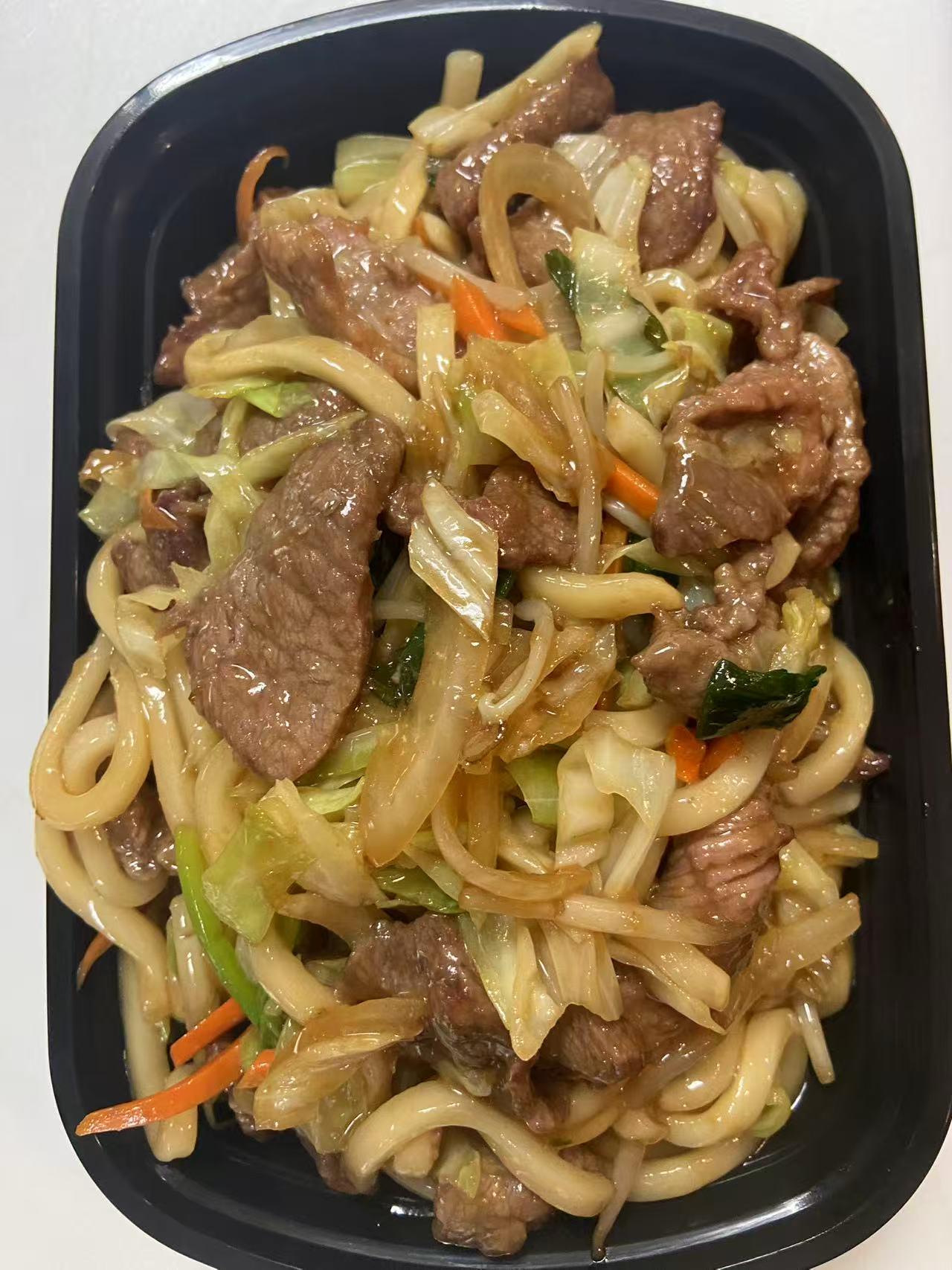 Beef lo mein with cabbage and carrots in a takeout box