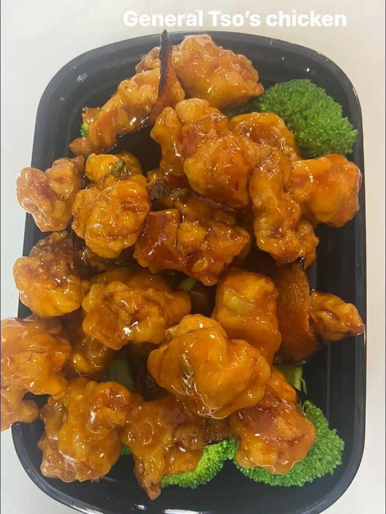 General Tso's chicken with broccoli in a takeout box