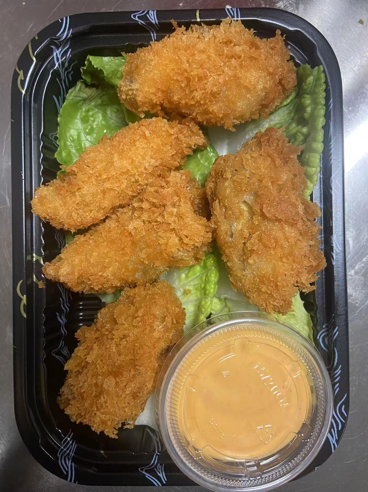 Crispy breaded bites on lettuce with a dipping sauce