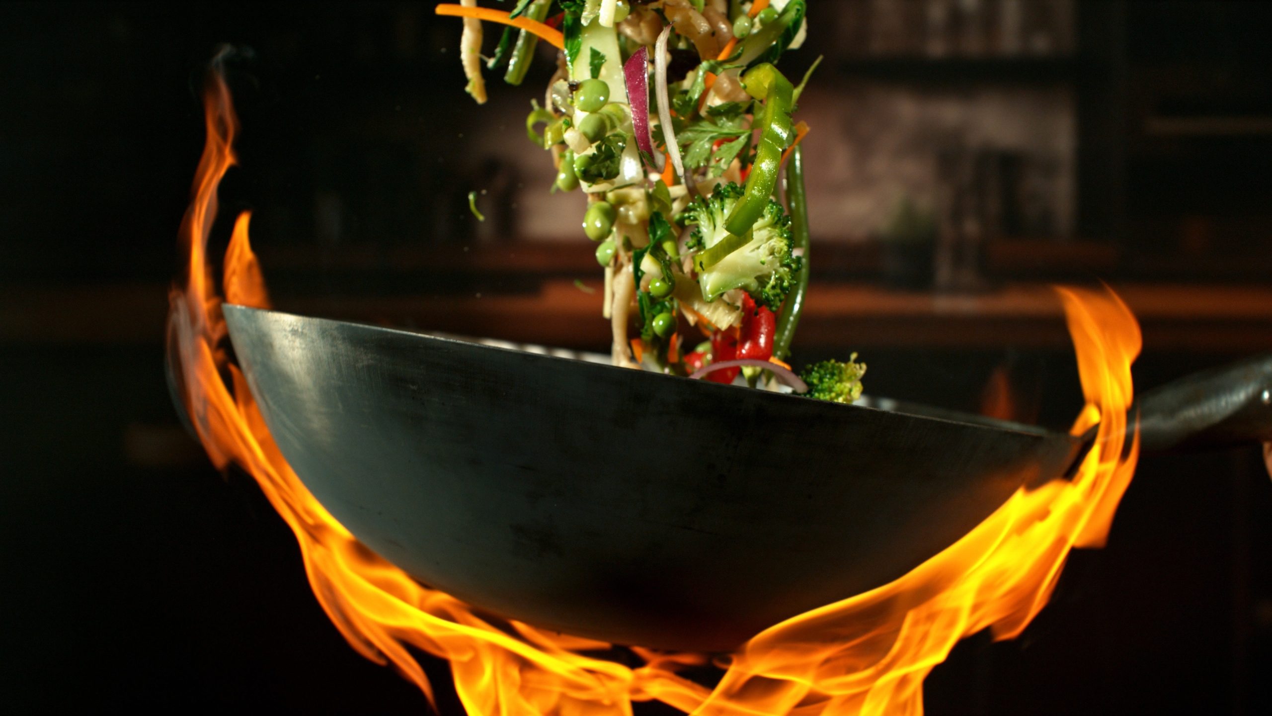 Wok stir-frying colorful vegetables over open flame at Chef Gong Chinese Restaurant in Lansing