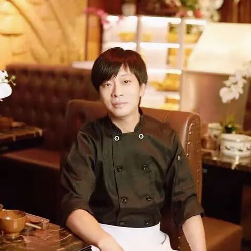 Chef Huang in uniform seated in the restaurant at Chef Huang, a Chinese Restaurant in New York