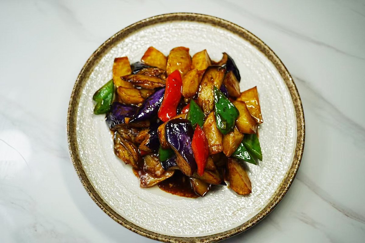 a hearty vegetable dish from Northeast China featuring fried eggplant, potatoes, and peppers in a umami sauce at Chef Ma，a Chinese Restaurant in Edison