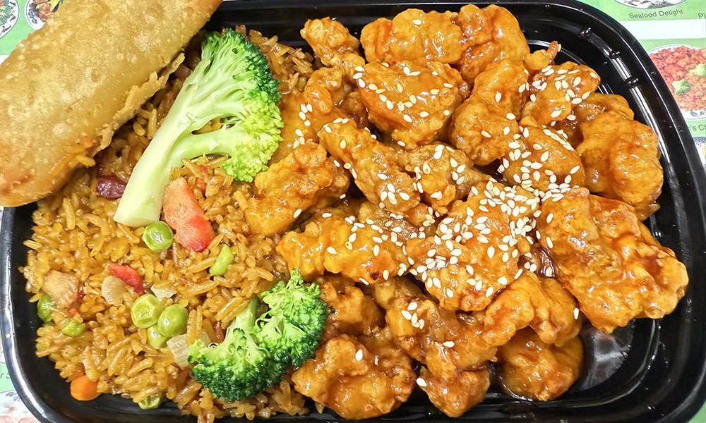 Sesame chicken, served with crispy rolls and rice with vegetables at China one,a Chinese Restaurant in Whitsett