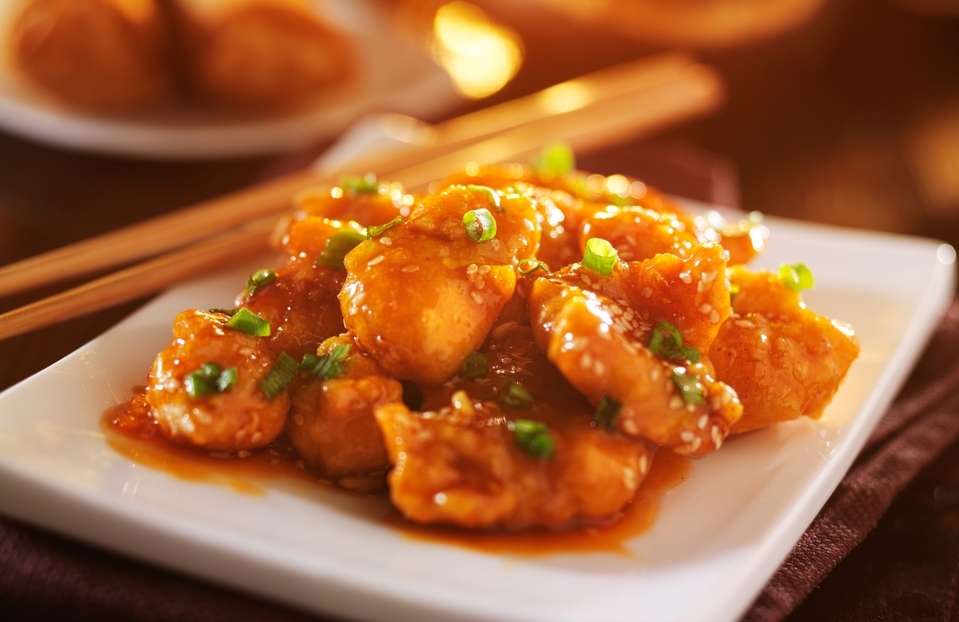Sesame chicken topped with green onion and sesame seeds