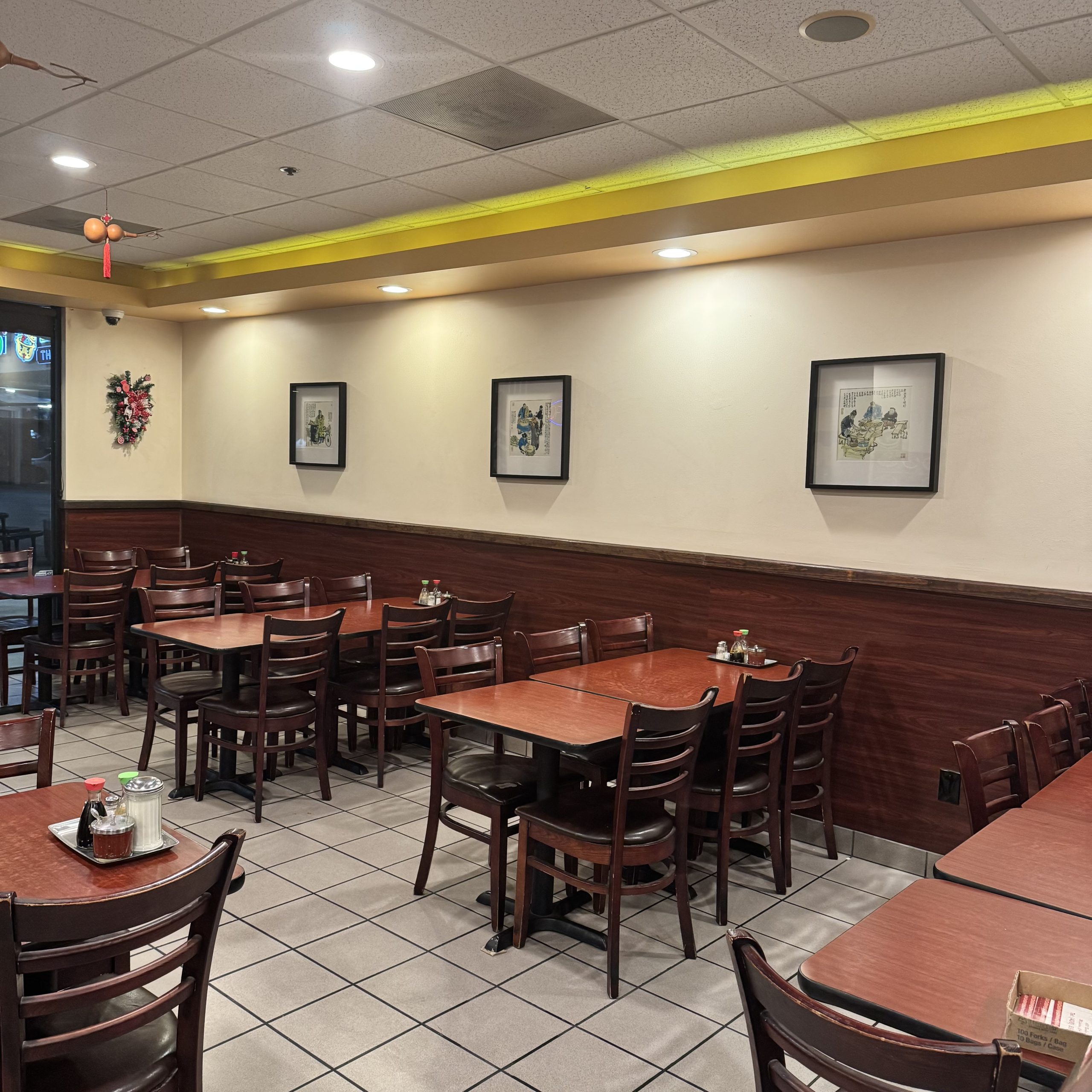 Neatly arranged tables and chairs with decorative artworks on walls at China Palace Restaurant, a Chinese Restaurant in Milpitas