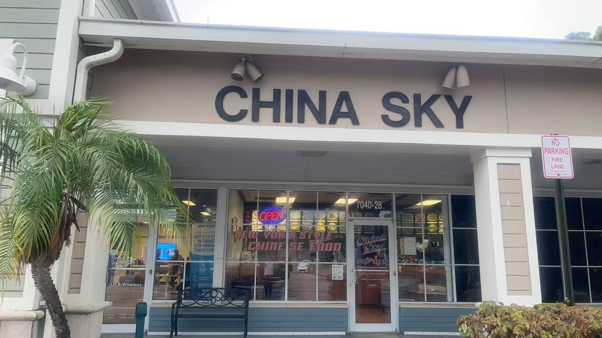 China-Sky-Chinese-Restaurant-Loxahatchee Front view of China Sky restaurant with large signage, glass windows, and a palm tree in the foreground.