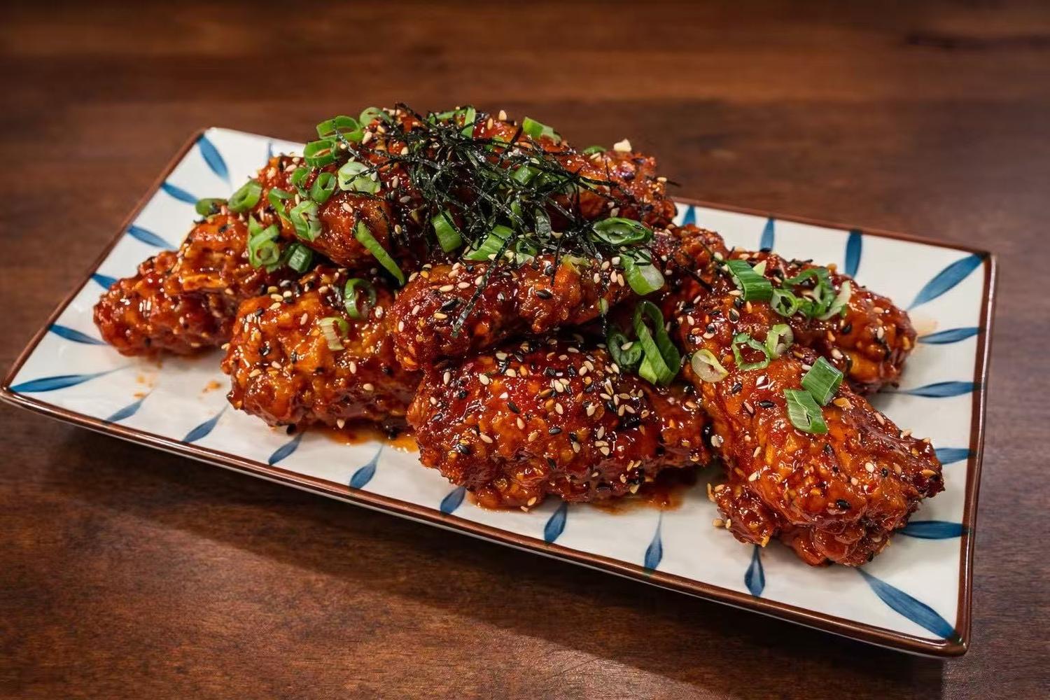 Spicy glazed fried chicken wings garnished with green onions, sesame and seaweed at Golden Dragon Restaurant a Chinese Restaurant in East Troy