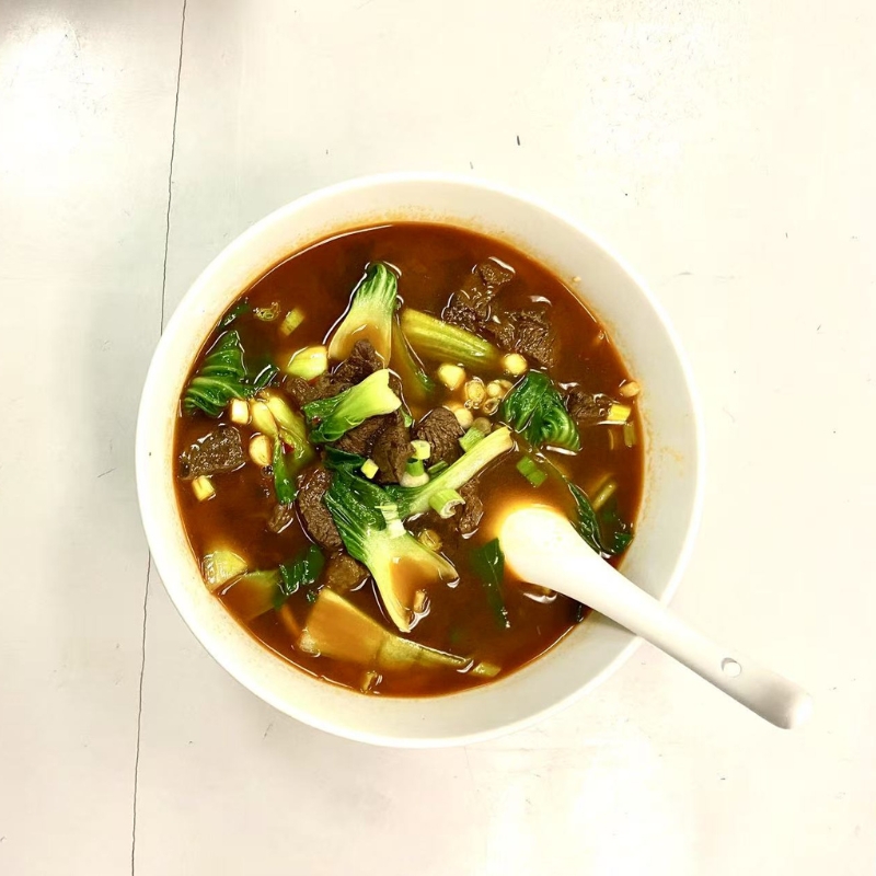 Beef noodle soup with tender beef, bok choy and corn.