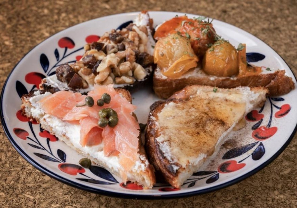 Plate of open-faced sandwiches with salmon, mushrooms, and cheese on a decorative plate.