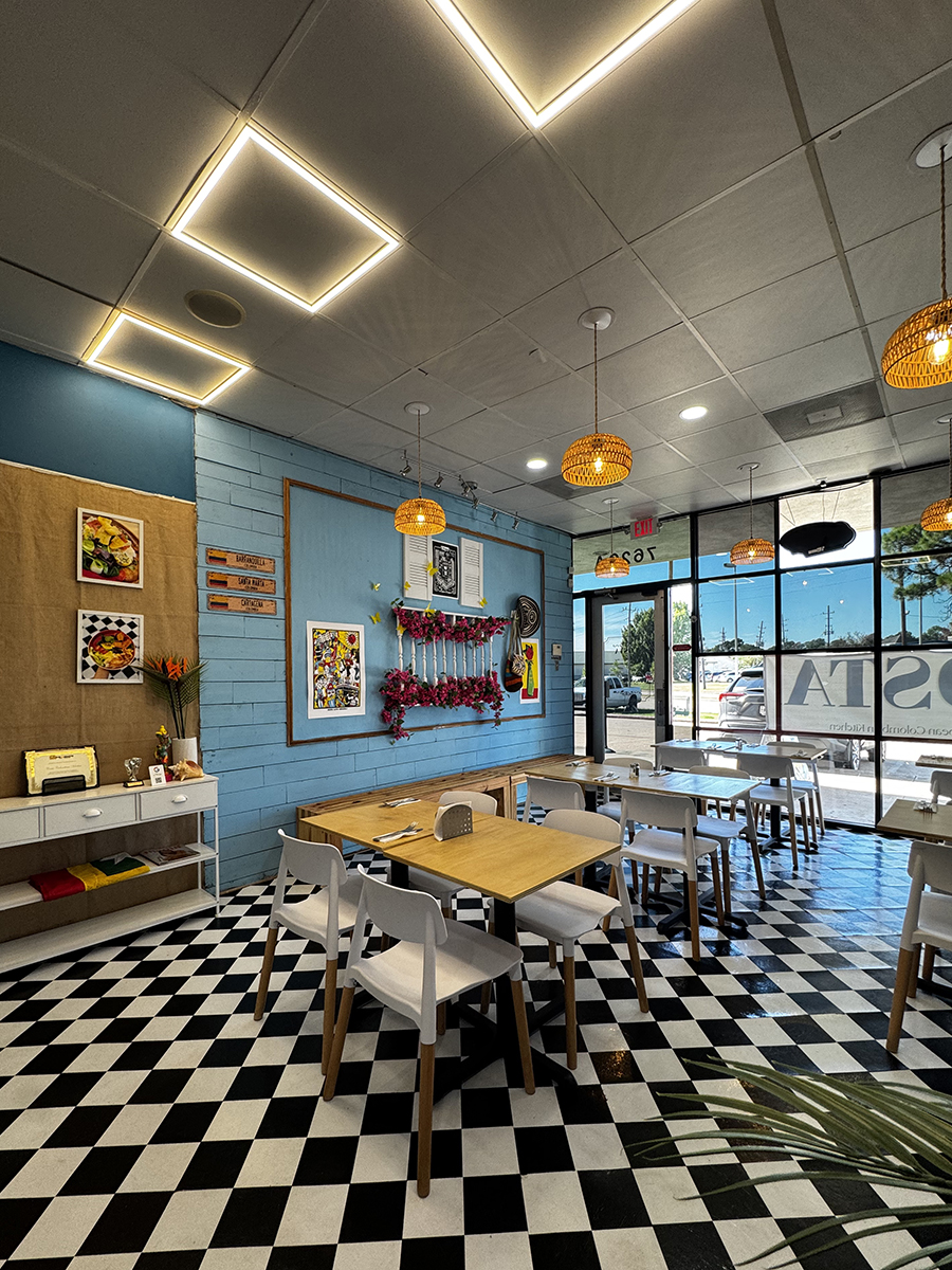 Restaurant interior with blue accent wall, floral decor, and checkered flooring