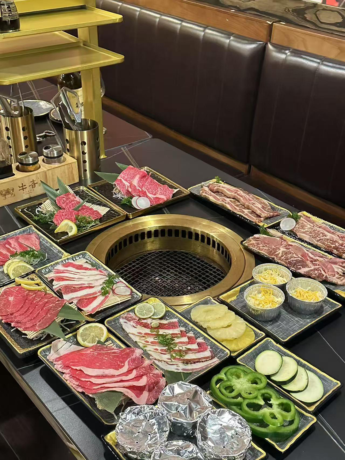Full table of grilled food set around golden barbecue grill