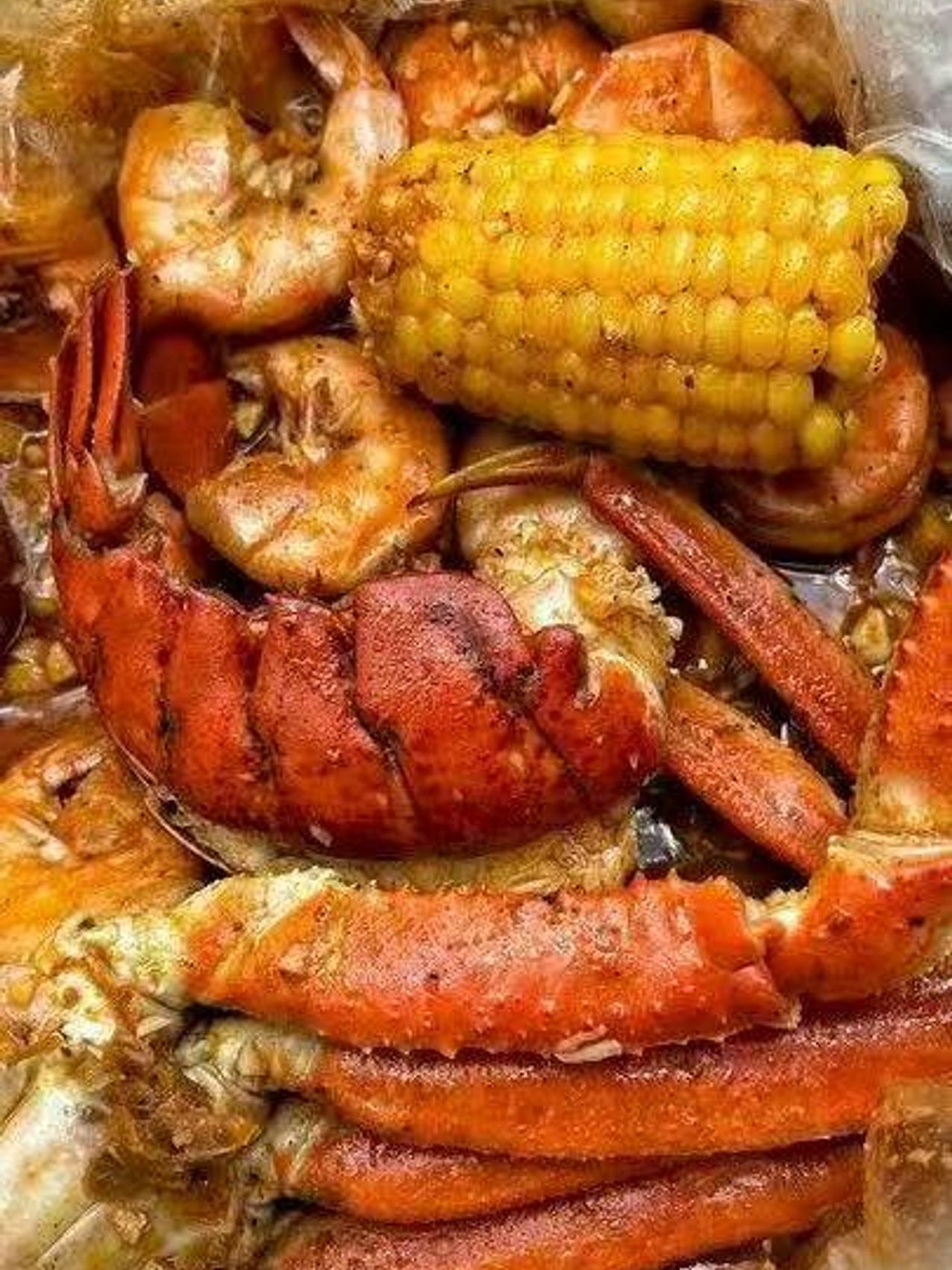 Close-up of crab claws, shrimp, and corn in a seafood boil