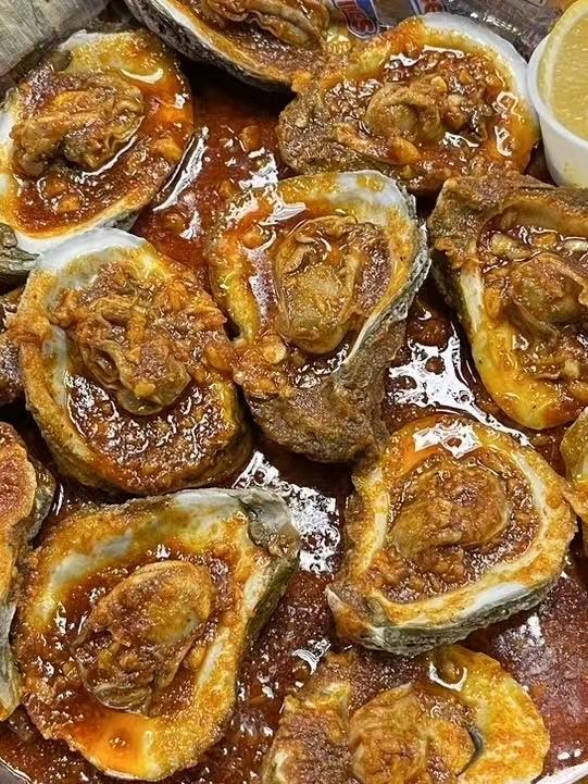 Oysters baked with spicy sauce, presenting a rich at Crabbers, a Seafood restaurant in Sarasota