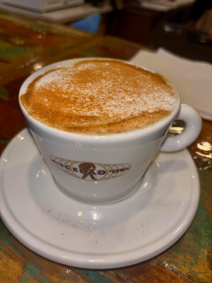 Cappuccino in a white cup with saucer at DA DAMASO，a Italian Restaurant in Staten Island