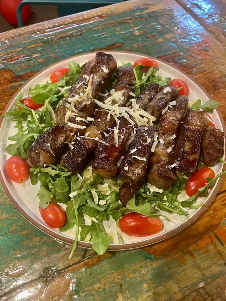 Grilled meat and veggies salad on a plate at DA DAMASO，a Italian Restaurant in Staten Island