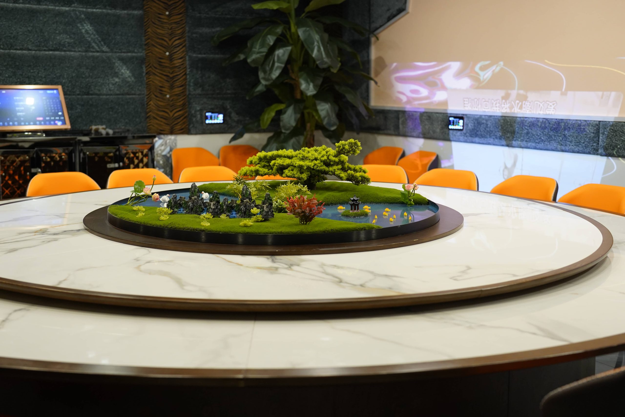 Private dining room with miniature landscape and orange chairs at Dak Sing Palace, a Chinese Restaurant in Brooklyn