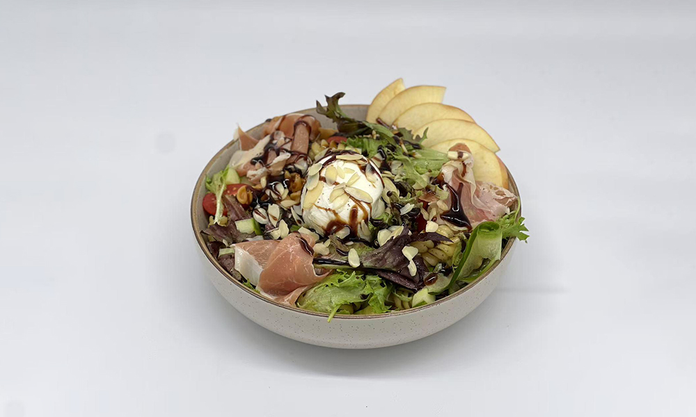 a bowl with burrata cheese, fruits and salad at Dandelion Kaffe，a Brunch Restaurant in Alameda