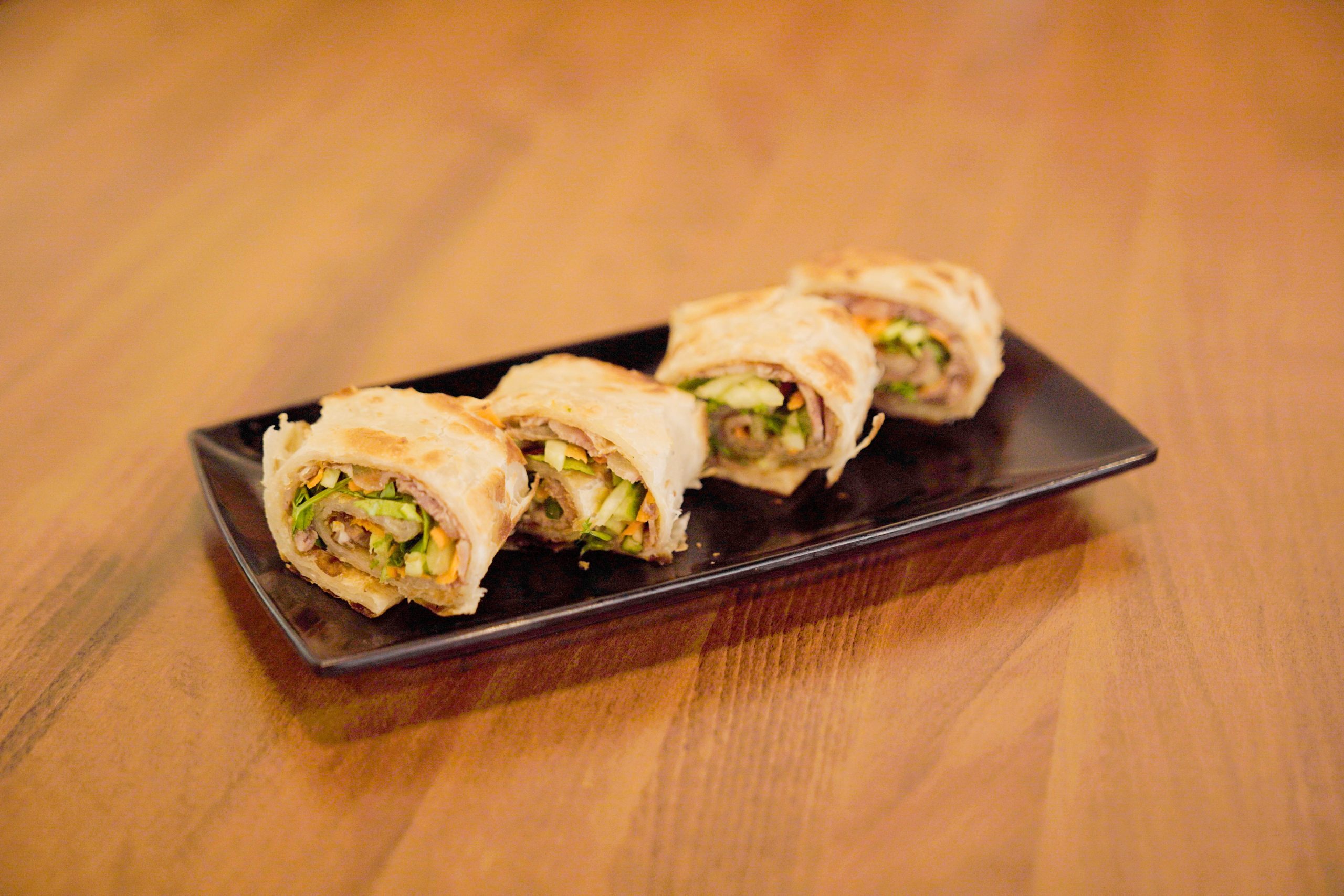 Beef roll pancakes with veggies on black plate at Dao Artisan Noodle, a Chinese Restaurant in San Leandro