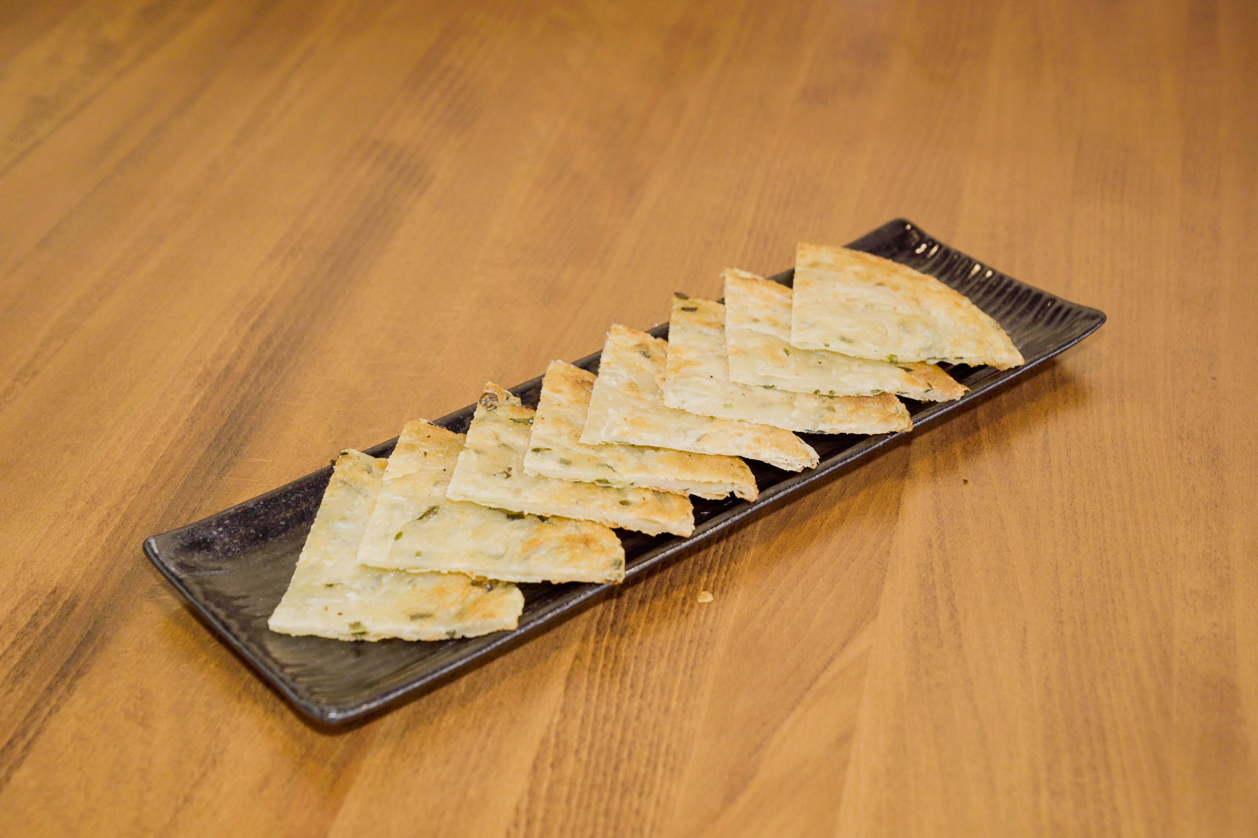 Flaky scallion pancake slices with aromatic green onions at Dao Artisan Noodle, a Chinese Restaurant in San Leandro