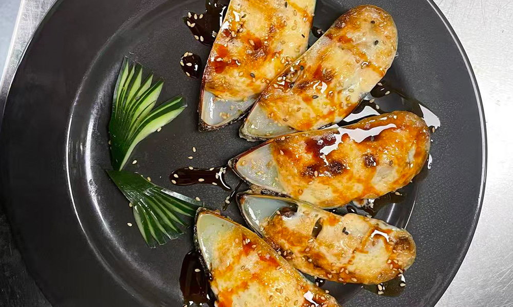 Baked green mussels with sesame seeds and savory sauce, a flavorful seafood dish at Devils Kitchen & Teppan, a Asian Restaurant in Eastvale