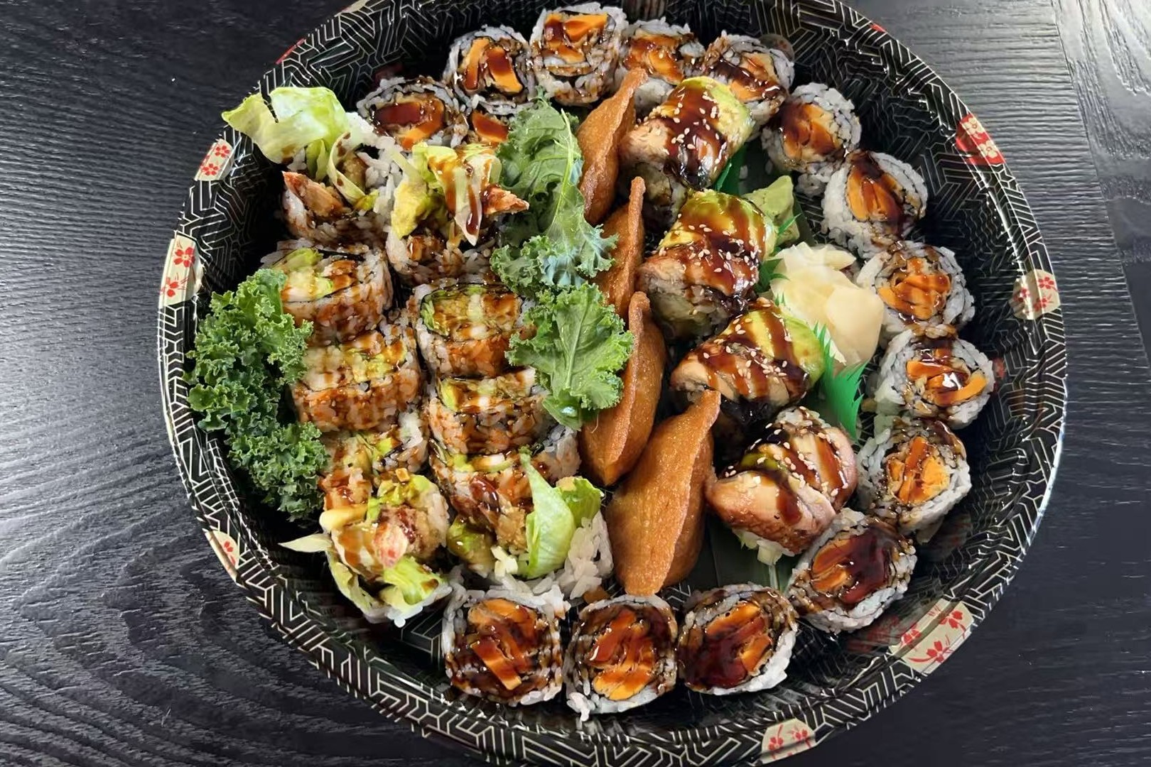 Dharma-Sushi&Grill-Japanese-Restaurant-Large-Sushi-Assortment-Schenectady A large assortment of sushi rolls, decorated with greens at Dharma Sushi & Grill, a Japanese Restaurant in Schenectady