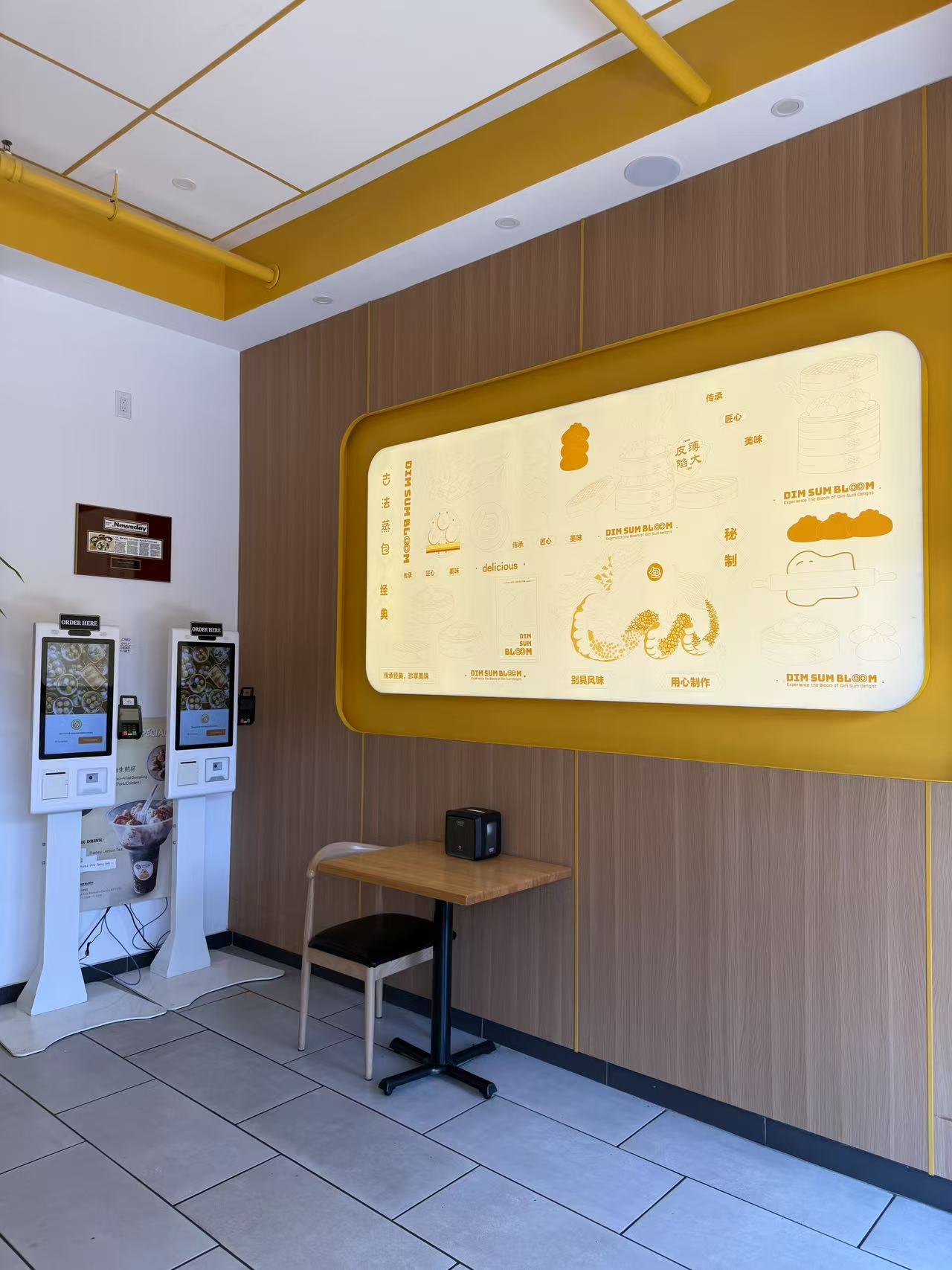 Modern self-order kiosk area with illuminated feature wall at Dim Sum Bloom Rockville Centre, a Chinese Restaurant in Rockville Centre