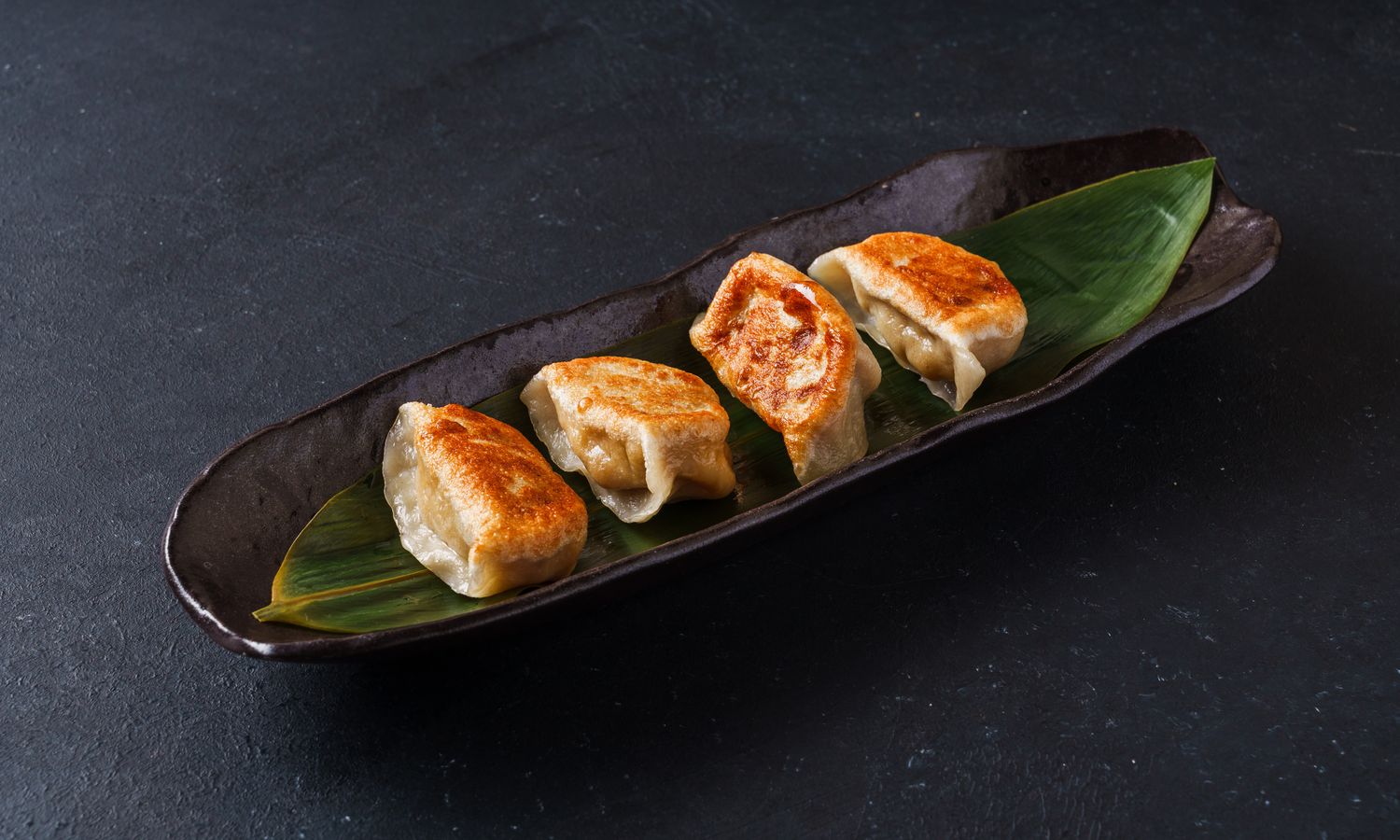 Crispy pan-fried dumplings with savory pork filling at Dim Sum Bloom Rockville Centre, a Chinese Restaurant in Rockville Centre