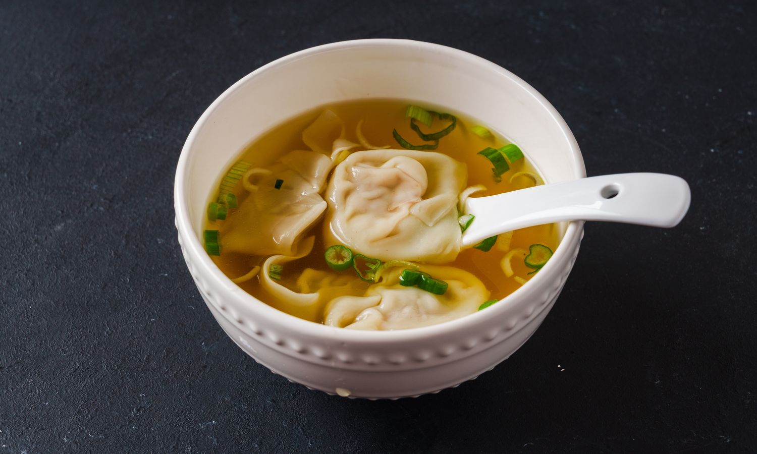 Savory pork wontons in clear broth with scallions at Dim Sum Bloom Rockville Centre, a Chinese Restaurant in Rockville Centre