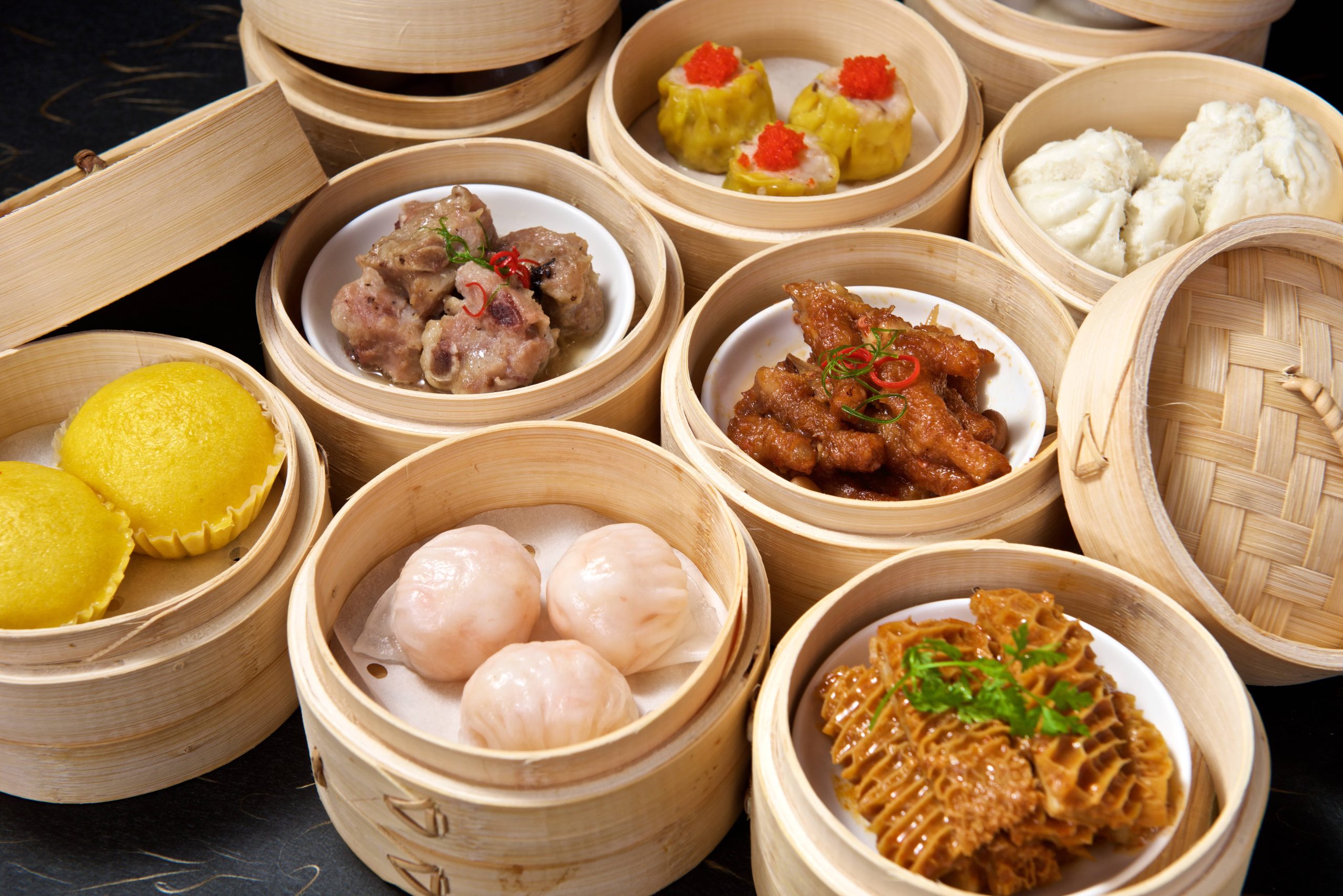 Assorted Dim Sum with shrimp dumplings, siu mai, buns, ribs, and tripe served in bamboo steamers