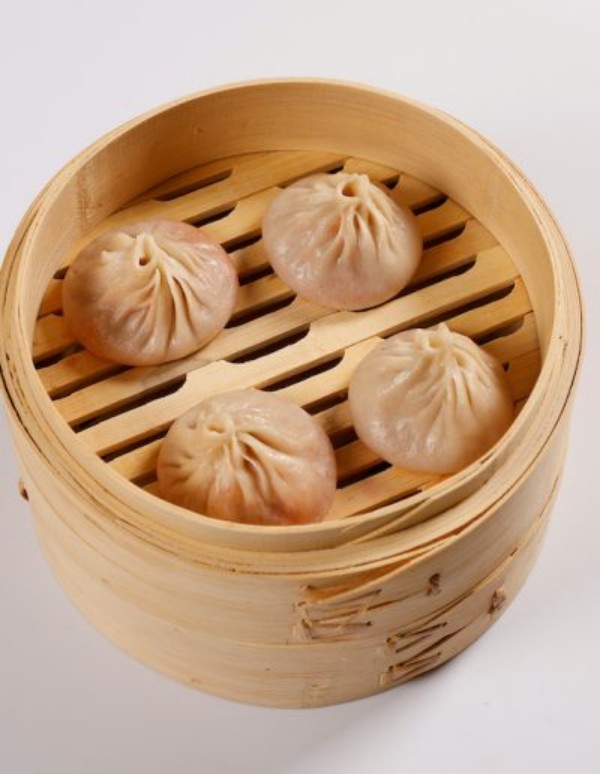 Four plain pork soup dumplings inside bamboo steamer at Tom's Dim Sum, a Dim Sum Restaurant in PA