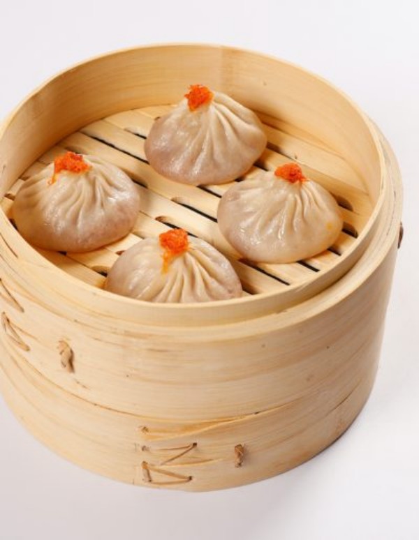 Four roe-topped soup dumplings in bamboo steamer at Tom's Dim Sum, a Dim Sum Restaurant in PA