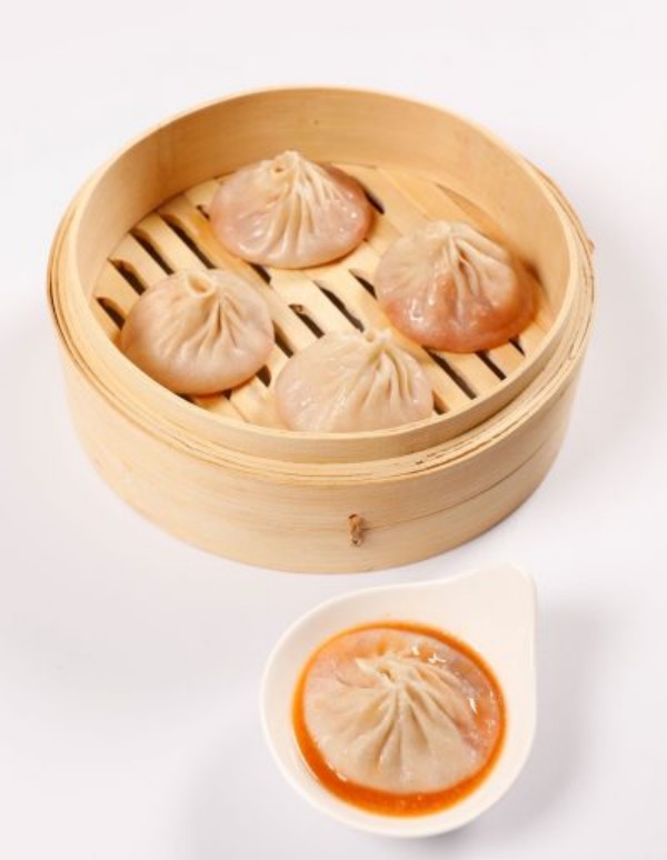 Pork soup dumplings with savory dipping sauce on side at Tom's Dim Sum, a Dim Sum Restaurant in PA