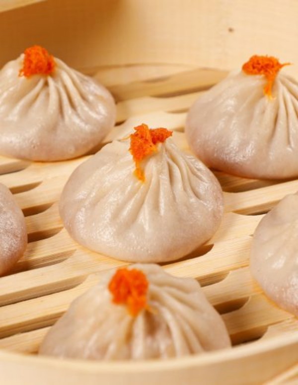 Soup dumplings topped with orange fish roe in bamboo steamer at Tom's Dim Sum, a Dim Sum Restaurant in PA