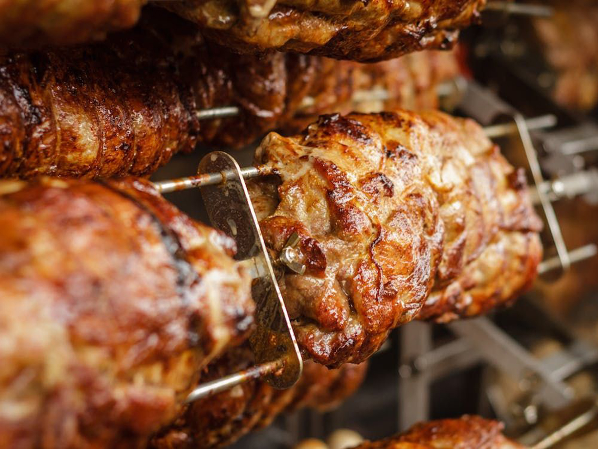 Rotisserie-roasted meat on vertical spits, glistening with juices at Ditan Er BBQ, a Barbecue restaurant in Flushing