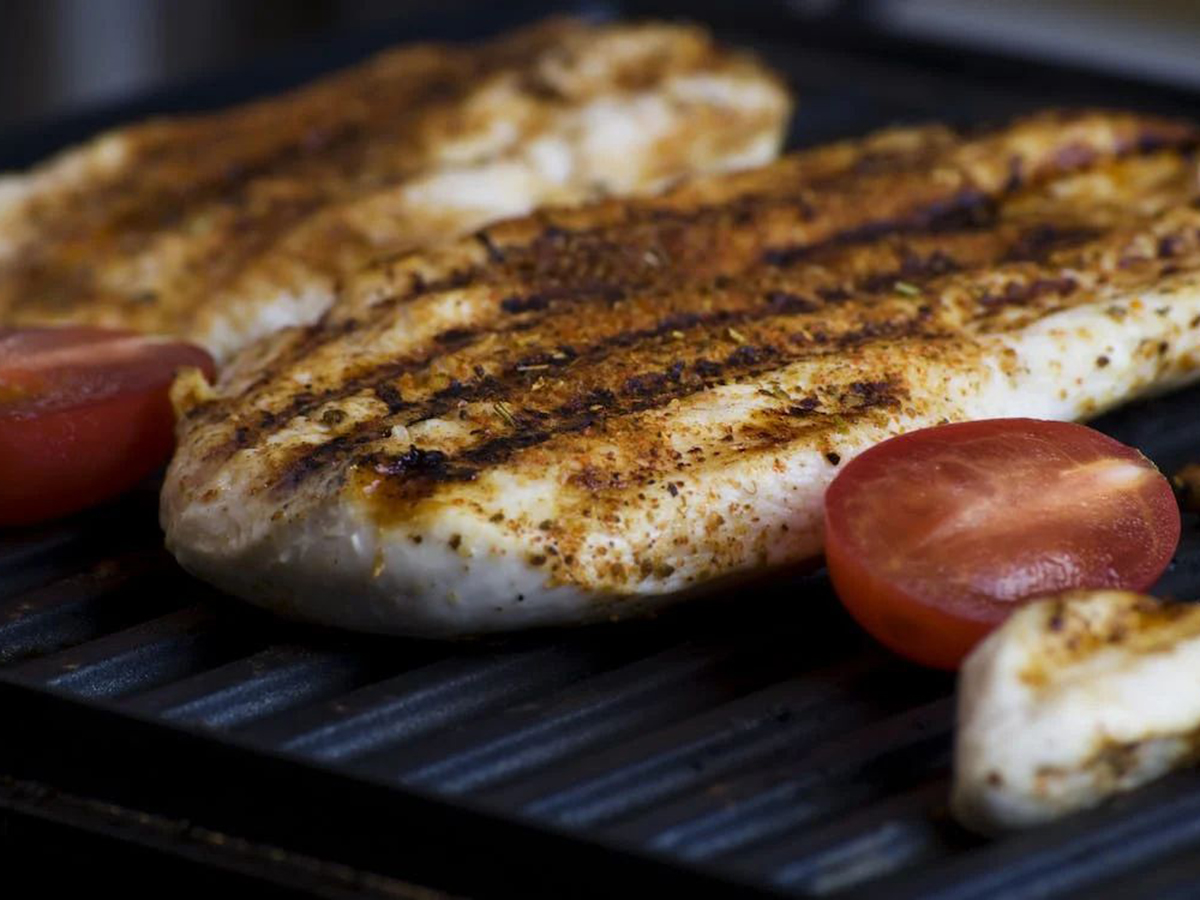 Spiced grilled chicken breast with char marks and tomatoes at Ditan Er BBQ, a Barbecue restaurant in Flushing