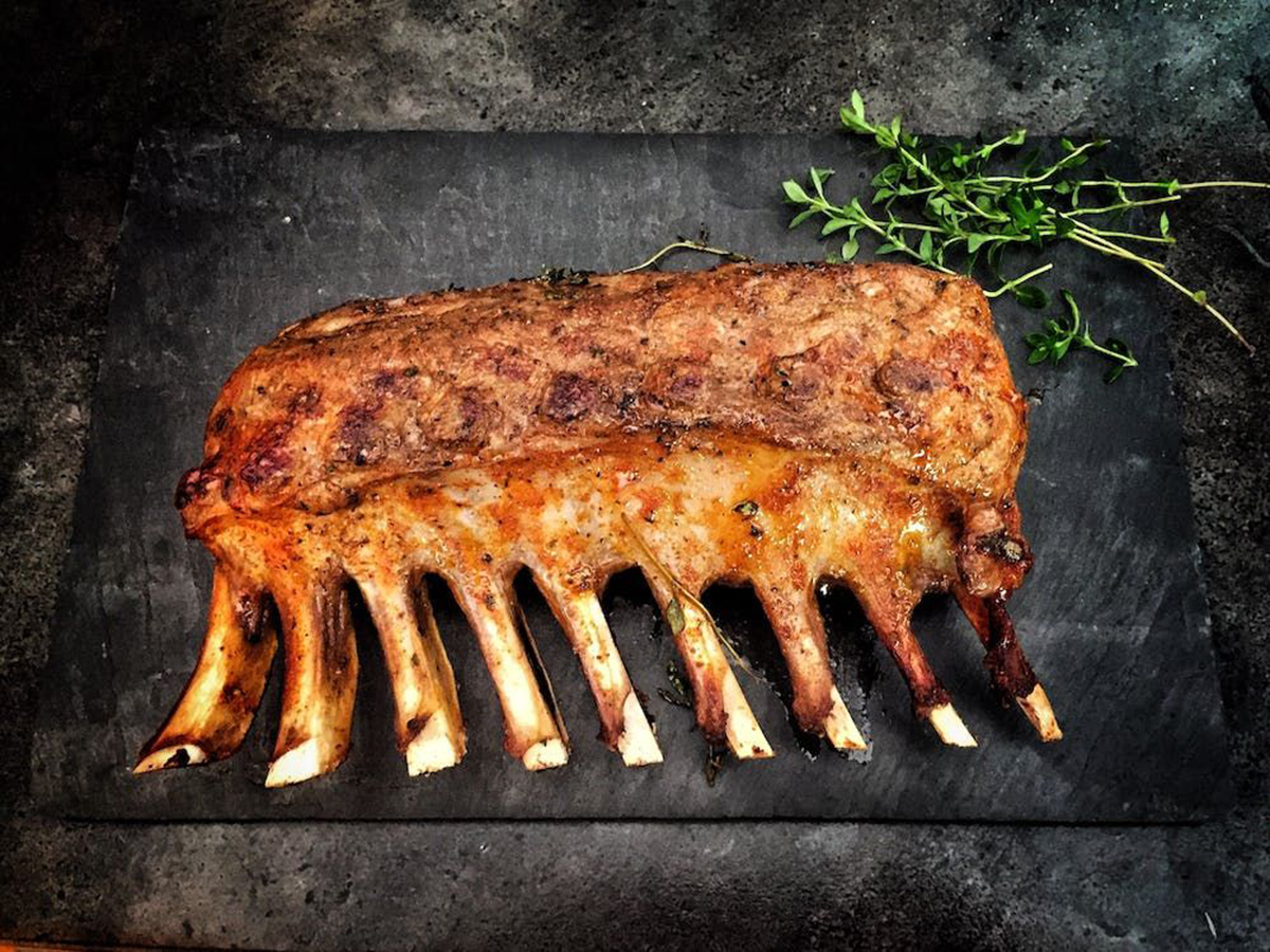 Roasted pork rib rack with herbs on a slate platter at Ditan Er BBQ, a Barbecue restaurant in Flushing